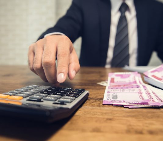 business-man-calculating-inr-bank-notes - INR